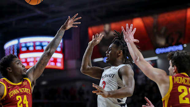  Feb 13, 2024; Cincinnati, Ohio, USA; Cincinnati Bearcats guard Jizzle James (2) passes the ball against Iowa State Cyclones forward Hason Ward (24) and forward Milan Momcilovic (22) in the second half at Fifth Third Arena. Mandatory Credit: Katie Stratman-USA TODAY Sports